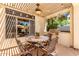 Cozy covered patio with ceiling fan, string lights and dining area with built-in grill at 2129 E Beautiful Ln, Phoenix, AZ 85042