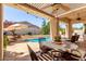 Inviting outdoor patio with a stone dining table overlooking the pool at 2129 E Beautiful Ln, Phoenix, AZ 85042