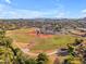 An aerial view of a well-maintained baseball field surrounded by trees, roads, and houses at 2234 N 74Th Way, Scottsdale, AZ 85257