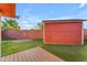 A spacious backyard with a small shed, brick fence, artificial turf, and a small deck at 2234 N 74Th Way, Scottsdale, AZ 85257