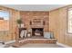 Cozy living room with a brick fireplace, wood paneling, built-in shelving, and natural light from two windows at 2234 N 74Th Way, Scottsdale, AZ 85257