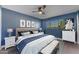 Relaxing main bedroom featuring blue walls, ceiling fan, art decor and window view at 2234 N 74Th Way, Scottsdale, AZ 85257