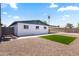 A tidy, low maintenance backyard featuring neutral rock ground cover, artificial turf, and white siding at 2706 W Isabella Ave, Mesa, AZ 85202