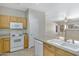 Kitchen with oak cabinets, white appliances, and a view into the living area at 2861 E Morenci Rd, San Tan Valley, AZ 85143