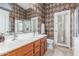 Bathroom with double sinks, dark wood cabinetry, toilet and a diamond patterned wall design at 29049 N Coal Ave, San Tan Valley, AZ 85143