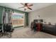 Bedroom setup with home gym equipment, large window, and desk for a functional and healthy lifestyle at 3061 W Betty Elyse Ln, Phoenix, AZ 85053