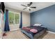 Bright bedroom featuring a large window with curtains, soft carpet, and a comfortable bed for relaxation at 3061 W Betty Elyse Ln, Phoenix, AZ 85053