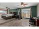 Spacious bedroom featuring a large bed, two ceiling fans, and a personal gym with windows offering natural light at 3061 W Betty Elyse Ln, Phoenix, AZ 85053