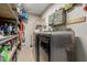 Laundry room area with modern washer/dryer, shelving, and storage solutions at 3061 W Betty Elyse Ln, Phoenix, AZ 85053