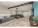 Open-concept living room with hardwood floors, sectional sofa, fireplace, and large window at 3061 W Betty Elyse Ln, Phoenix, AZ 85053