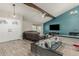 Open living room featuring wood plank flooring, vaulted ceilings, a TV, and modern furniture at 3061 W Betty Elyse Ln, Phoenix, AZ 85053