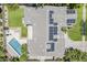 An aerial view of a home showcasing a pool, patio, lush lawn, and a roof covered in solar panels at 3062 E Cullumber St, Gilbert, AZ 85234