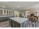 Open-concept kitchen featuring a center island with seating, white cabinets, and seamless flow into the living spaces at 3062 E Cullumber St, Gilbert, AZ 85234