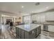 Open-concept kitchen featuring a center island with seating, white cabinets, and seamless flow into the living spaces at 3062 E Cullumber St, Gilbert, AZ 85234