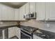 Well-appointed kitchen showcasing white cabinets, black granite countertops, and stainless steel appliances at 3062 E Cullumber St, Gilbert, AZ 85234