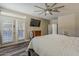 Bright main bedroom features a ceiling fan, TV, French doors, and wood-look floors at 3062 E Cullumber St, Gilbert, AZ 85234