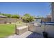 Outdoor kitchen with stainless steel grill and bench seating in a well-maintained backyard, perfect for gatherings at 3062 E Cullumber St, Gilbert, AZ 85234