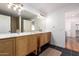 Double vanity in a modern bathroom features stylish lighting and natural wood cabinets at 3150 E Beardsley Rd # 1081, Phoenix, AZ 85050