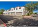 Townhome exterior featuring multiple car garages, white stucco, and red window frames at 3150 E Beardsley Rd # 1081, Phoenix, AZ 85050