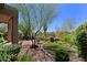 Well-manicured backyard featuring a brick patio, lush landscaping, and vibrant green space at 32710 N 71St St, Scottsdale, AZ 85266