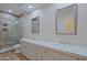 Luxurious bathroom with a double vanity, framed mirrors and glass enclosed tiled shower at 32710 N 71St St, Scottsdale, AZ 85266