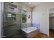 Glass shower and bathtub combo with stone tile, recessed lights and a window at 32710 N 71St St, Scottsdale, AZ 85266