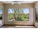 Sunlit bedroom boasts a large window with verdant views of the desert landscaping at 32710 N 71St St, Scottsdale, AZ 85266