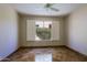 Cozy bedroom with tiled floors, ceiling fan, and large shuttered window with outside views at 32710 N 71St St, Scottsdale, AZ 85266