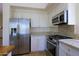 Close-up of kitchen featuring stainless appliances, granite countertops and white cabinetry at 32710 N 71St St, Scottsdale, AZ 85266