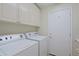 Well-equipped laundry room with a washer, dryer, upper cabinets and a door at 32710 N 71St St, Scottsdale, AZ 85266