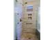 Tiled shower stall with glass door, built in shelves, grab bar and rain shower head at 32710 N 71St St, Scottsdale, AZ 85266