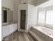 Spacious bathroom with a soaking tub, glass-enclosed shower, and vanity with white cabinets at 3314 E Draper Cir, Mesa, AZ 85213