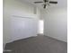 Bedroom with neutral carpet, closet, and open door to a kitchen at 3314 E Draper Cir, Mesa, AZ 85213