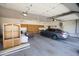 Spacious garage with built-in storage, ceiling fans, and a parked car at 3314 E Draper Cir, Mesa, AZ 85213