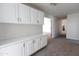 Bright living space with white built-in cabinets and beige carpeting leading to a doorway at 3314 E Draper Cir, Mesa, AZ 85213