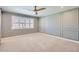 Cozy bedroom featuring grey walls with trim, a ceiling fan, and a large window at 3344 N 62Nd Pl, Scottsdale, AZ 85251