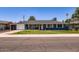 Charming single-story home boasts a well-manicured lawn, blue paint, and updated windows for a modern look at 3344 N 62Nd Pl, Scottsdale, AZ 85251