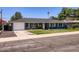 Charming single-story home boasts a well-manicured lawn, blue paint, and updated windows for a modern look at 3344 N 62Nd Pl, Scottsdale, AZ 85251