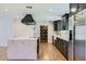 Beautiful kitchen featuring a marble island, stainless steel appliances, and dark green cabinets at 3344 N 62Nd Pl, Scottsdale, AZ 85251