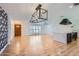Bright and airy living area showcasing wood floors, a statement light fixture and modern kitchen island at 3344 N 62Nd Pl, Scottsdale, AZ 85251