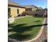 Manicured backyard showcasing a pristine lawn and tidy landscaping at 45091 W Gavilan Dr, Maricopa, AZ 85139