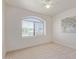 Neutral bedroom with carpeted floor, arched window, and a ceiling fan at 4933 E Downing St, Mesa, AZ 85205