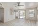 Open living area featuring light wood flooring, ceiling fan, and sliding glass doors to outdoor patio at 4933 E Downing St, Mesa, AZ 85205