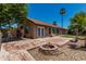 Spacious backyard featuring a brick fire pit and door leading into the home at 647 W Mission Dr, Chandler, AZ 85225