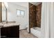 Bright bathroom features a dark wood vanity with a granite countertop and a shower with brown tile at 647 W Mission Dr, Chandler, AZ 85225