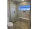 Bathroom featuring tiled shower with glass door and stone flooring at 647 W Mission Dr, Chandler, AZ 85225