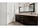 Bathroom featuring a granite double vanity with dark cabinets and a large framed mirror at 647 W Mission Dr, Chandler, AZ 85225