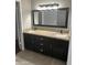Bathroom vanity with granite countertop, dual sinks, and black wood cabinetry at 647 W Mission Dr, Chandler, AZ 85225