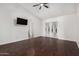 Bedroom with wood floors, ceiling fan, television, and glass door access to the backyard at 647 W Mission Dr, Chandler, AZ 85225