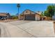 Single-story home with a two-car garage, driveway, and xeriscaped yard with trees at 647 W Mission Dr, Chandler, AZ 85225